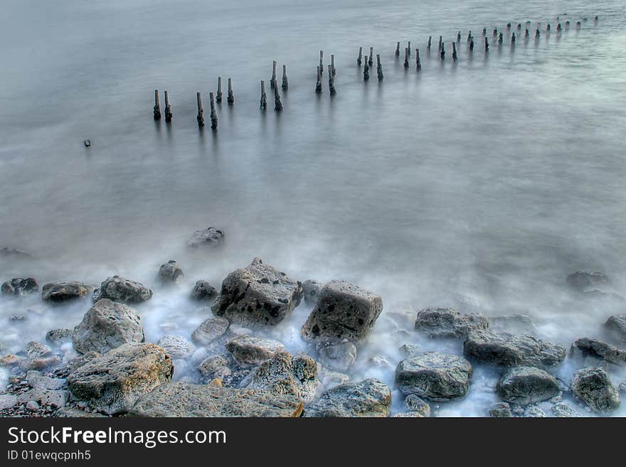 Old wooden columns at a destroyed pier. Old wooden columns at a destroyed pier