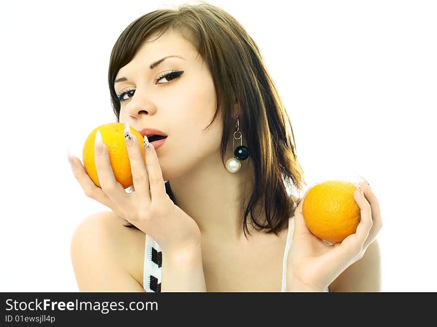 Sexy brunette woman eating oranges