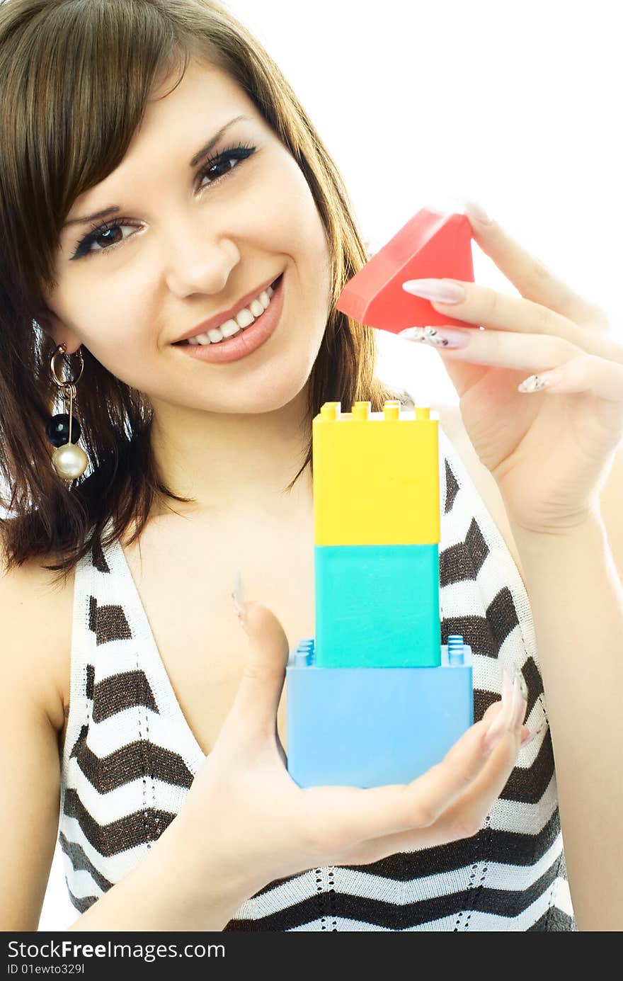 Portrait of a beautiful young woman building a toy house