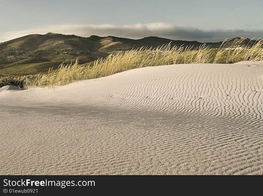 Detail of a sand dune with Sintra mountain at background. Detail of a sand dune with Sintra mountain at background