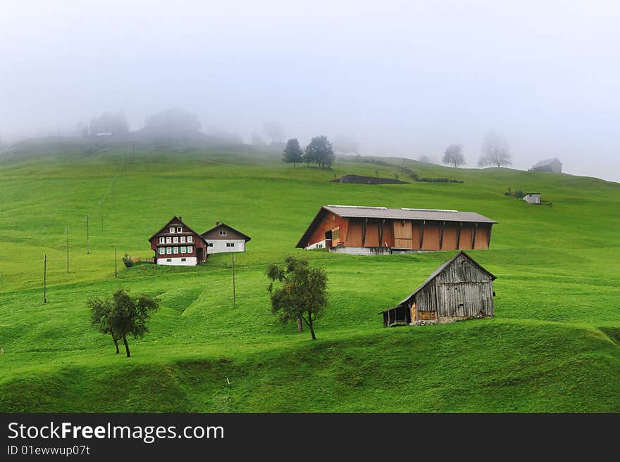 Cloudy time in Swiss alps, miniature chalet on the green mountains slope. Cloudy time in Swiss alps, miniature chalet on the green mountains slope