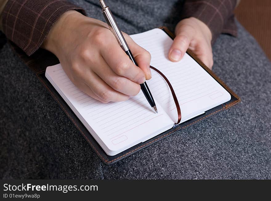 Female hand writes notes in notebook