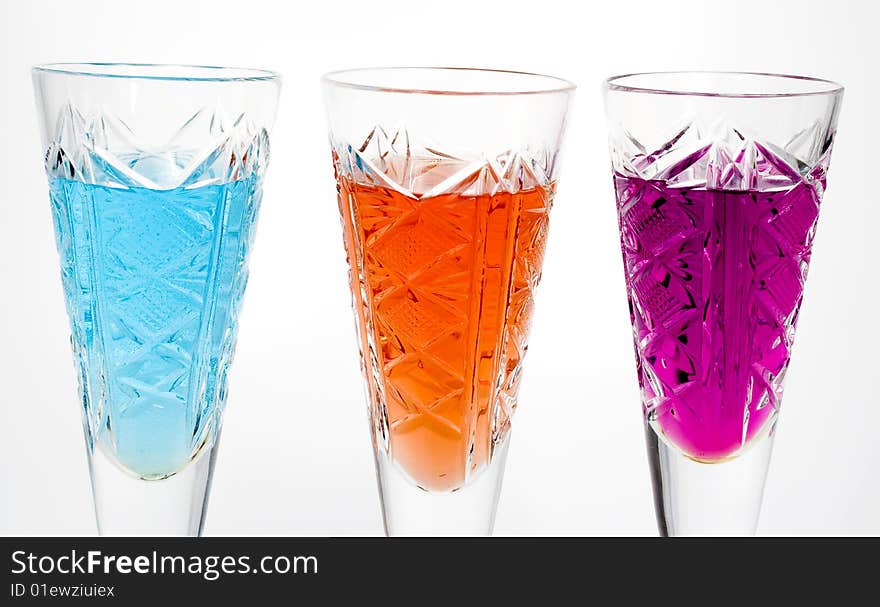 Three wineglass with drink blue, red and magenta colors