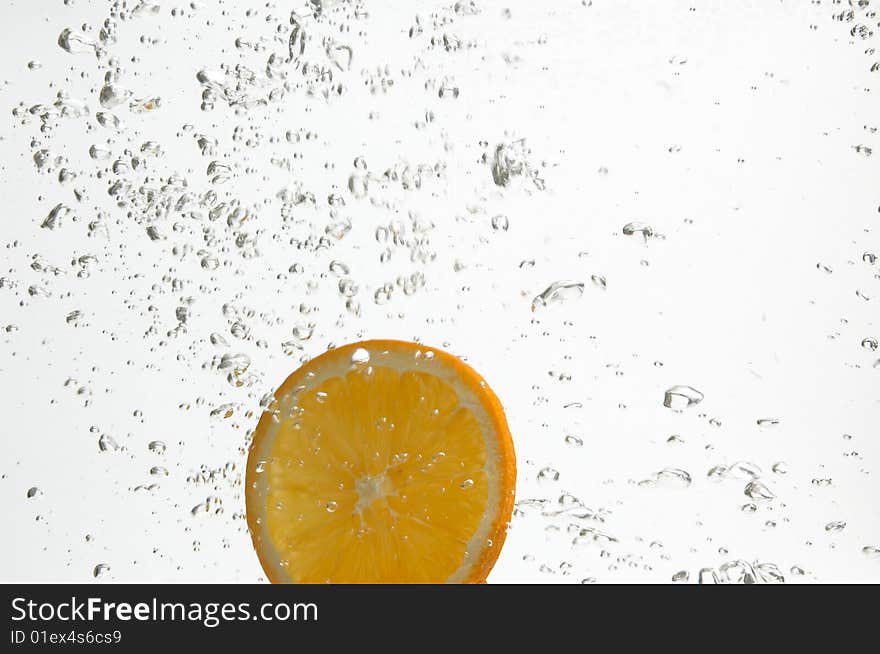 Slice of orange is dropped into fresh water. Slice of orange is dropped into fresh water.