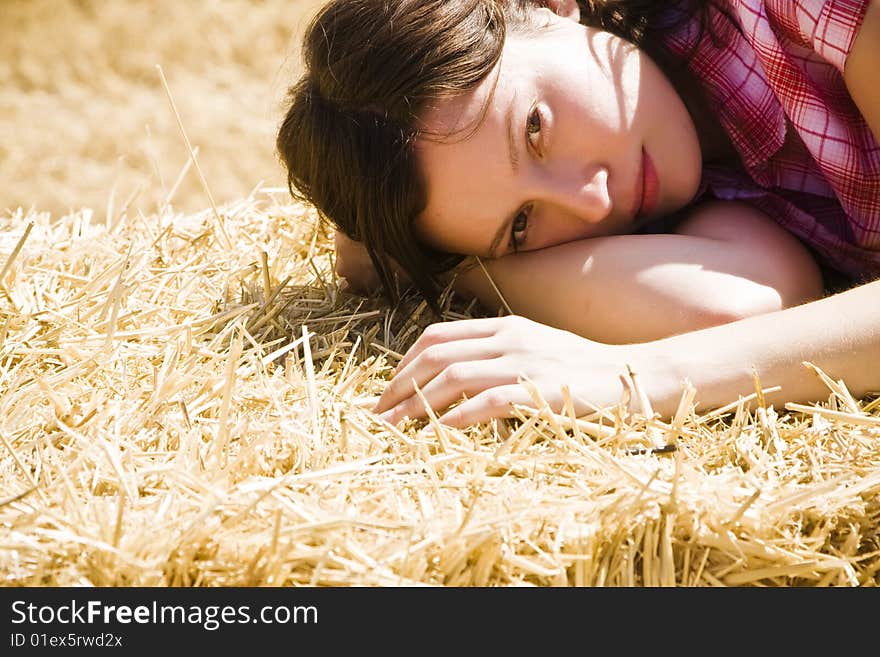 Young farmer laying on haystack under the sun. Young farmer laying on haystack under the sun.