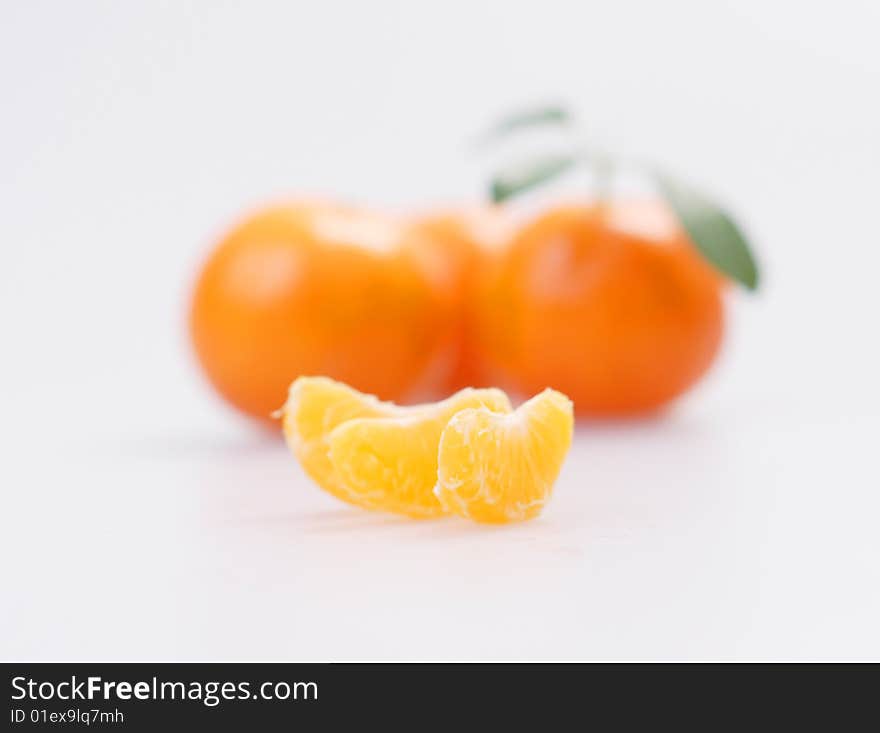 Three clementines with segments on a white background