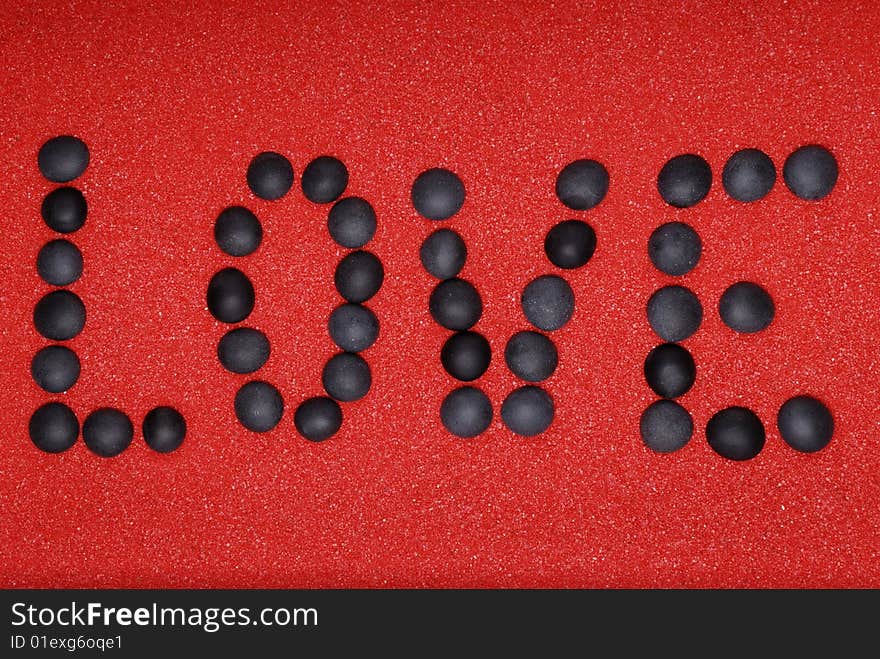 Word love from stones on red sand. Word love from stones on red sand