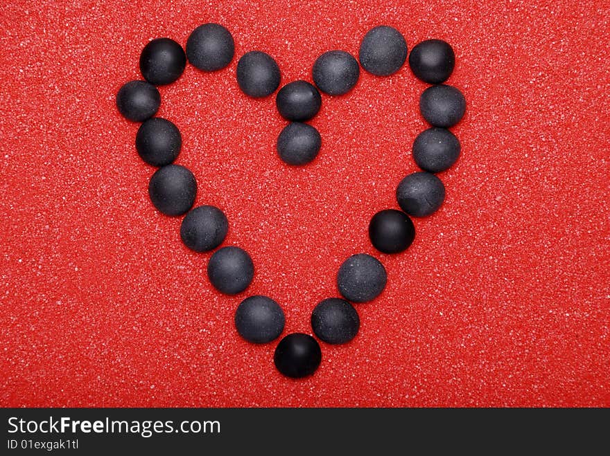 Black heart from stones on red sand. Black heart from stones on red sand