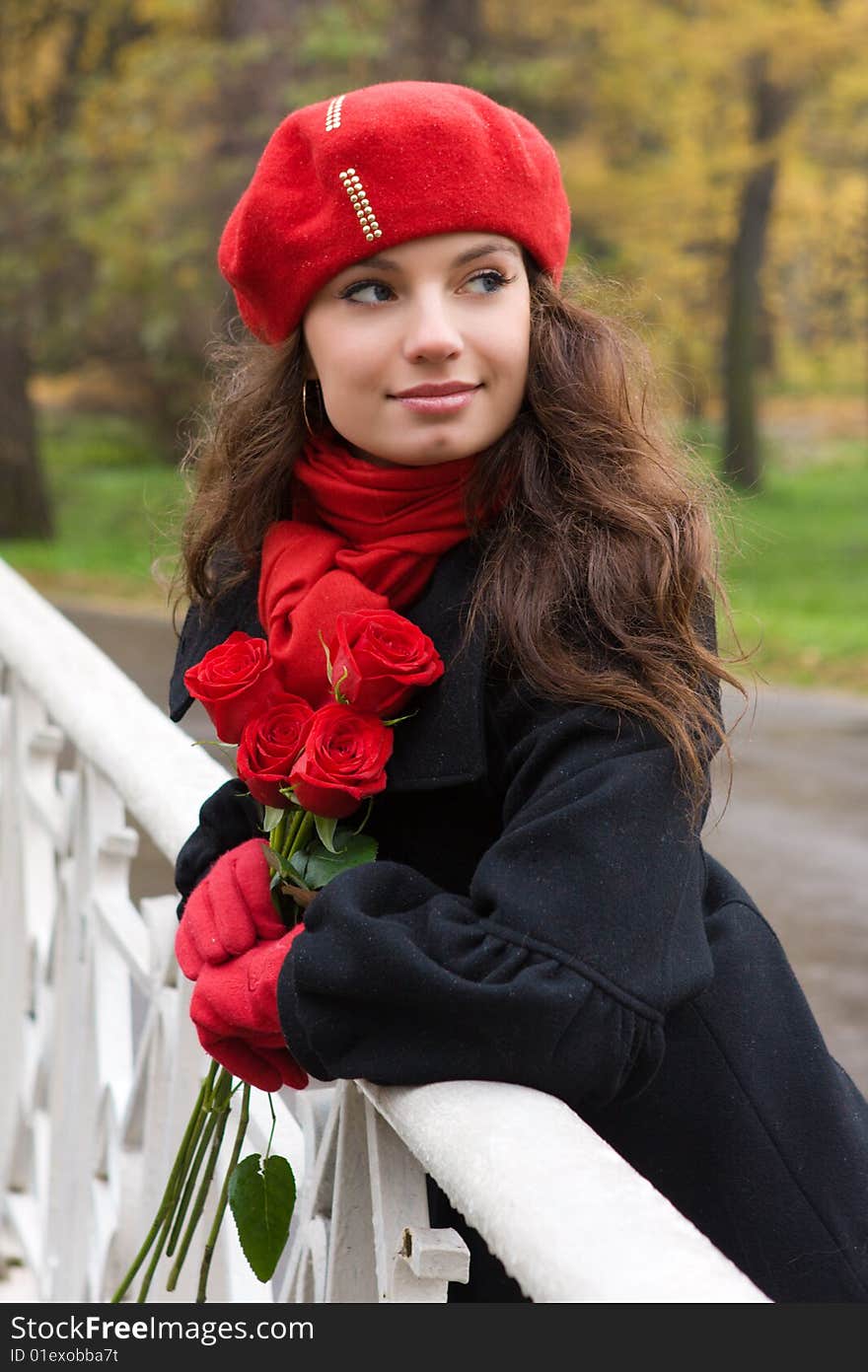 Romantic girl with roses in the autumn park