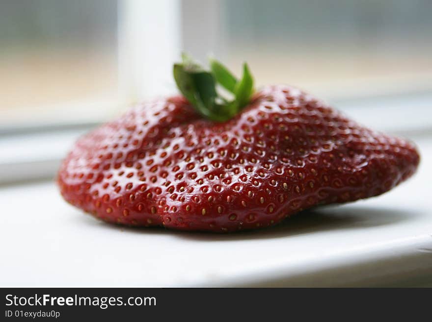 Close-up shot of a abnormally large strawberry.