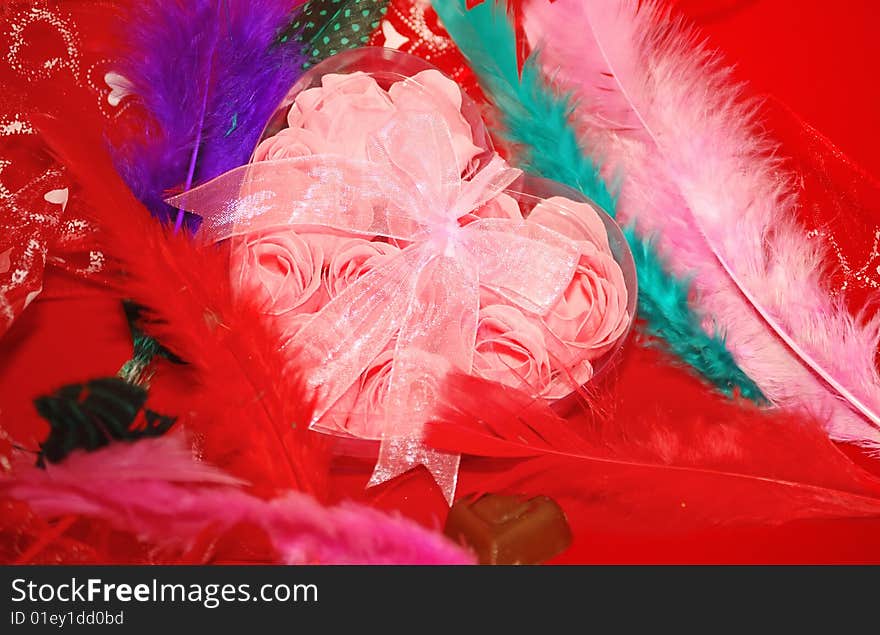 Valentines box and color feathers on the red