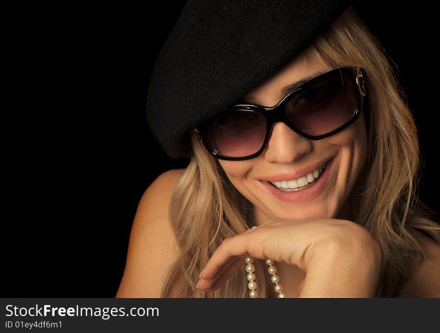 Beautiful portrait of a blond woman wearing sunglasses, hat, and pearls. Beautiful portrait of a blond woman wearing sunglasses, hat, and pearls.