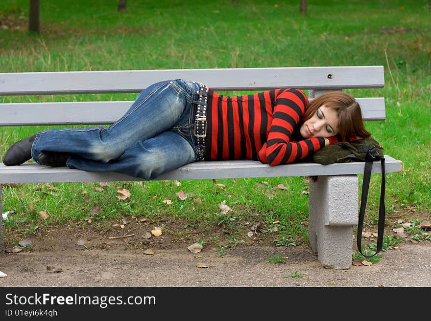 Young girl sleeping on a park bench