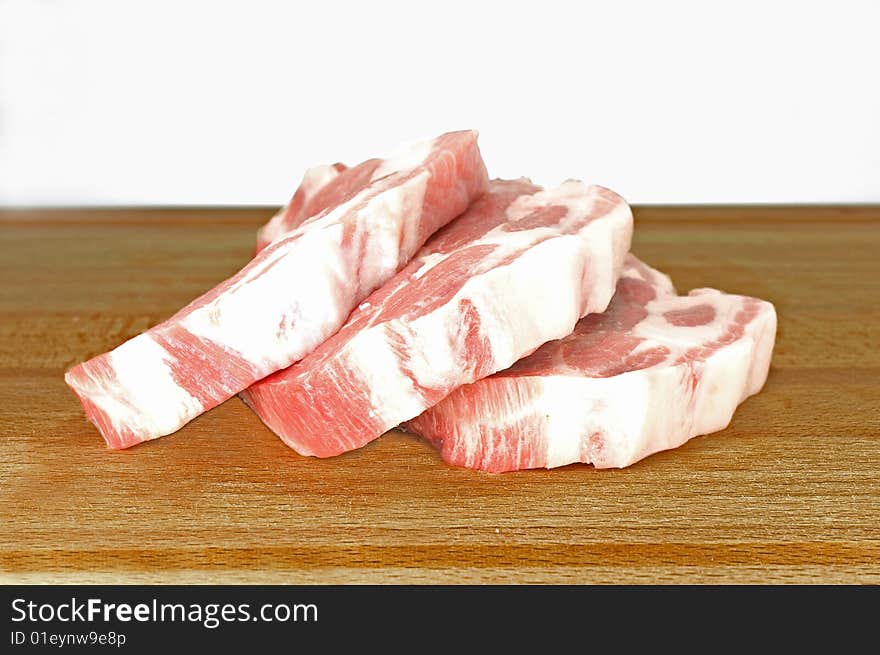Three slices of pork chops on a wooden cutting board. Three slices of pork chops on a wooden cutting board.
