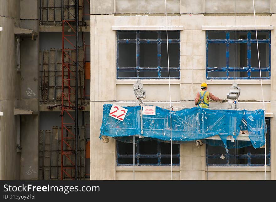 Cement layer in a gondola finishing the exterior of a flat with cement and a trowel