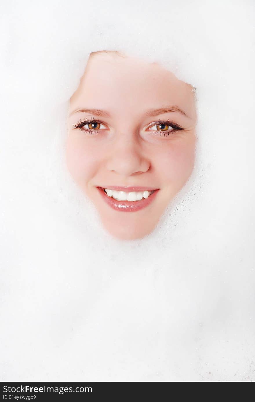 Face of a beautiful woman in white foam. Face of a beautiful woman in white foam