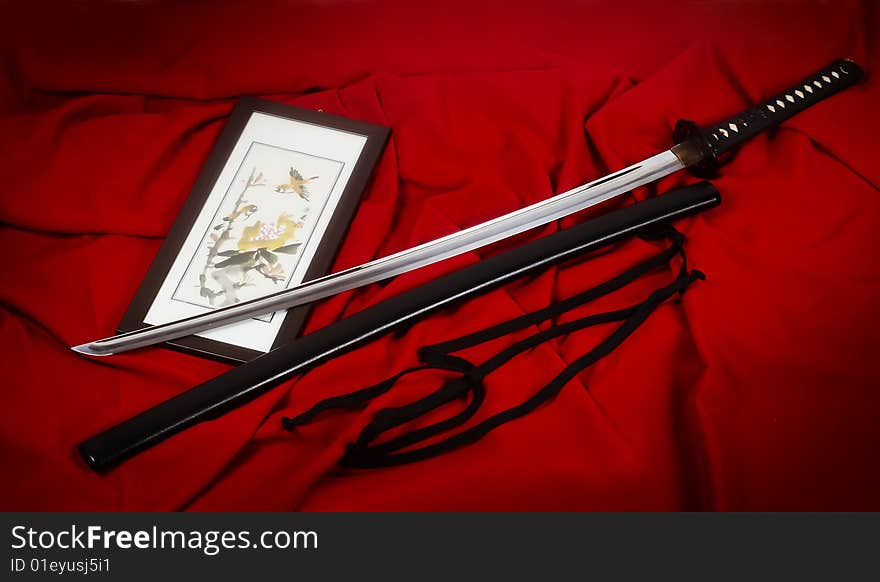 Real Japanese sword and picture on a red fabric
