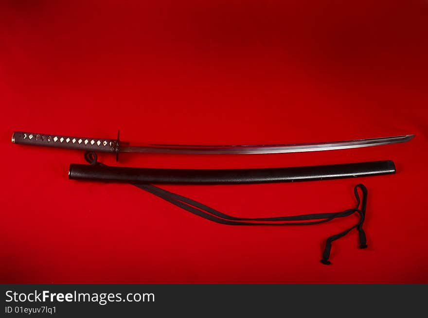 Real Japanese sword and picture on a red fabric. Real Japanese sword and picture on a red fabric
