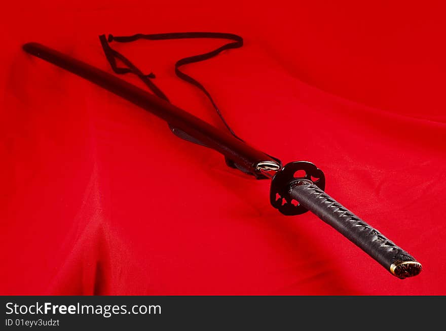 Real Japanese sword and picture on a red fabric. Real Japanese sword and picture on a red fabric