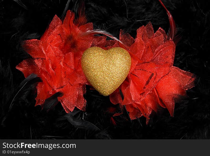 Golden heart over black feathers background