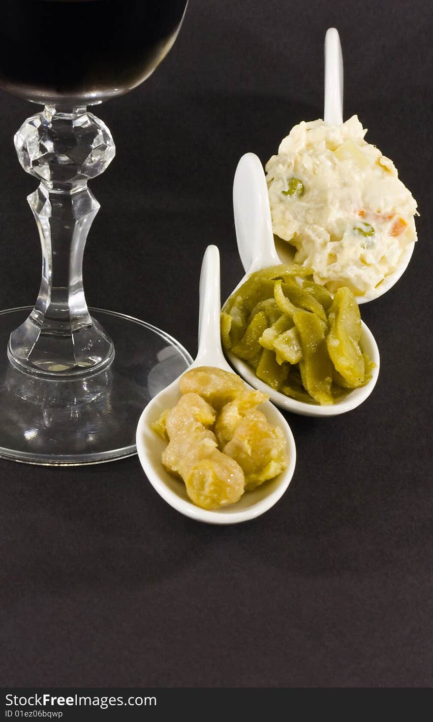 Russian salad, chick-peas and cases in white spoon