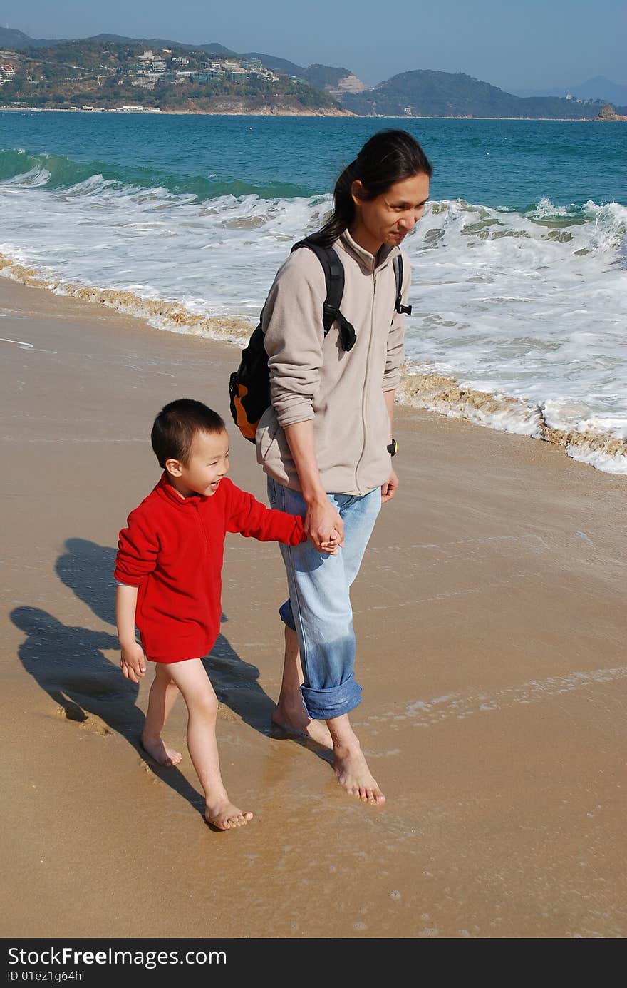 Father and Son Walking in the surfy beach