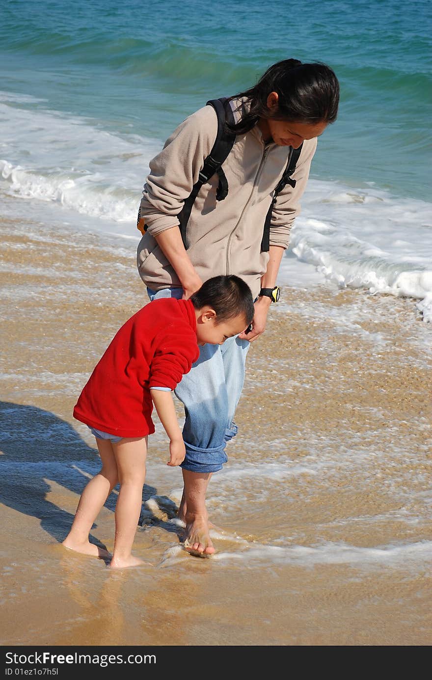 Father and son playing in the surfy beach