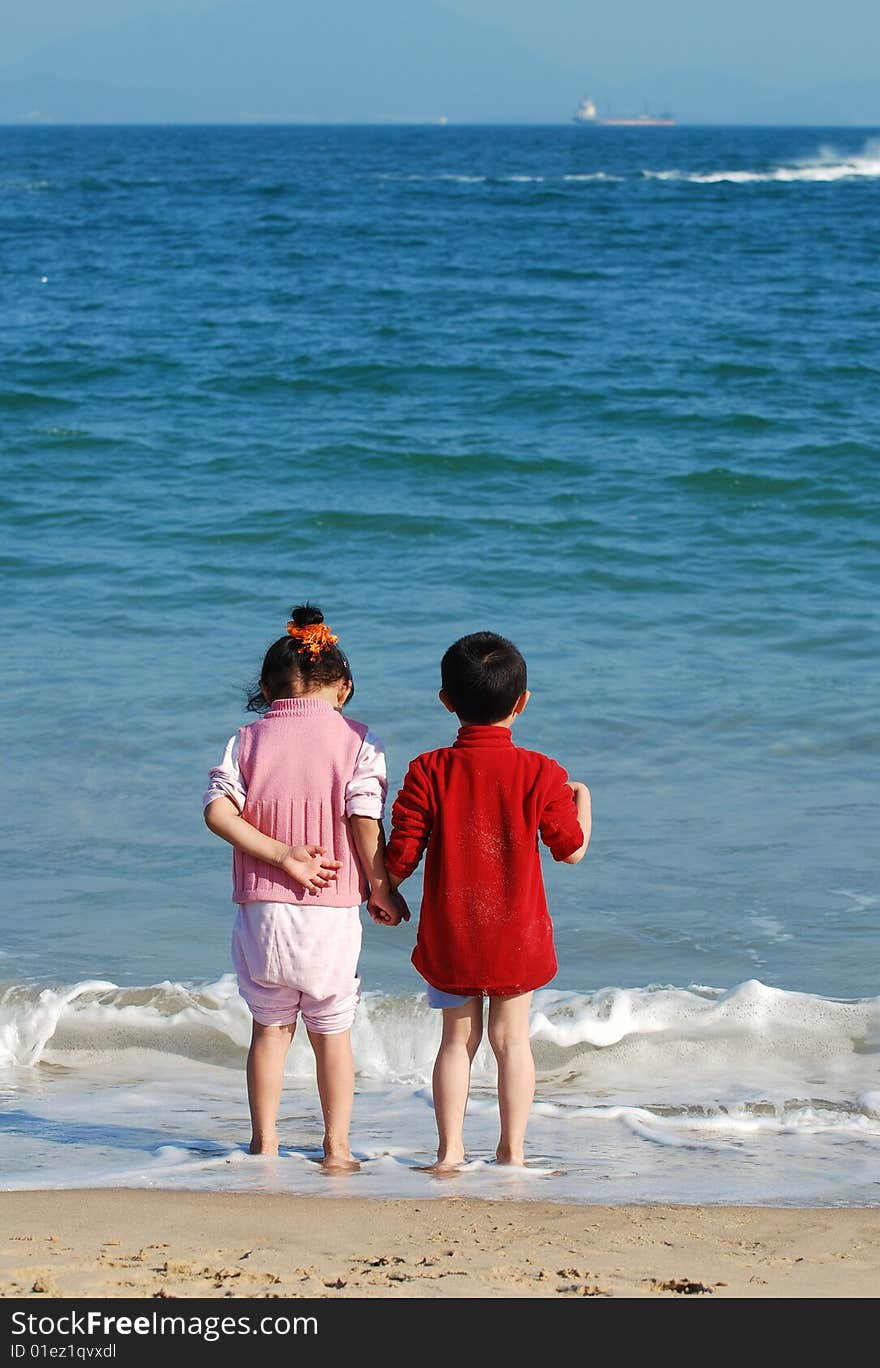 Young Kids Playing in the surfy beach. Young Kids Playing in the surfy beach