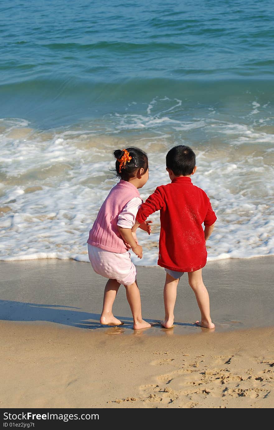 Young Kids Playing in the surfy beach