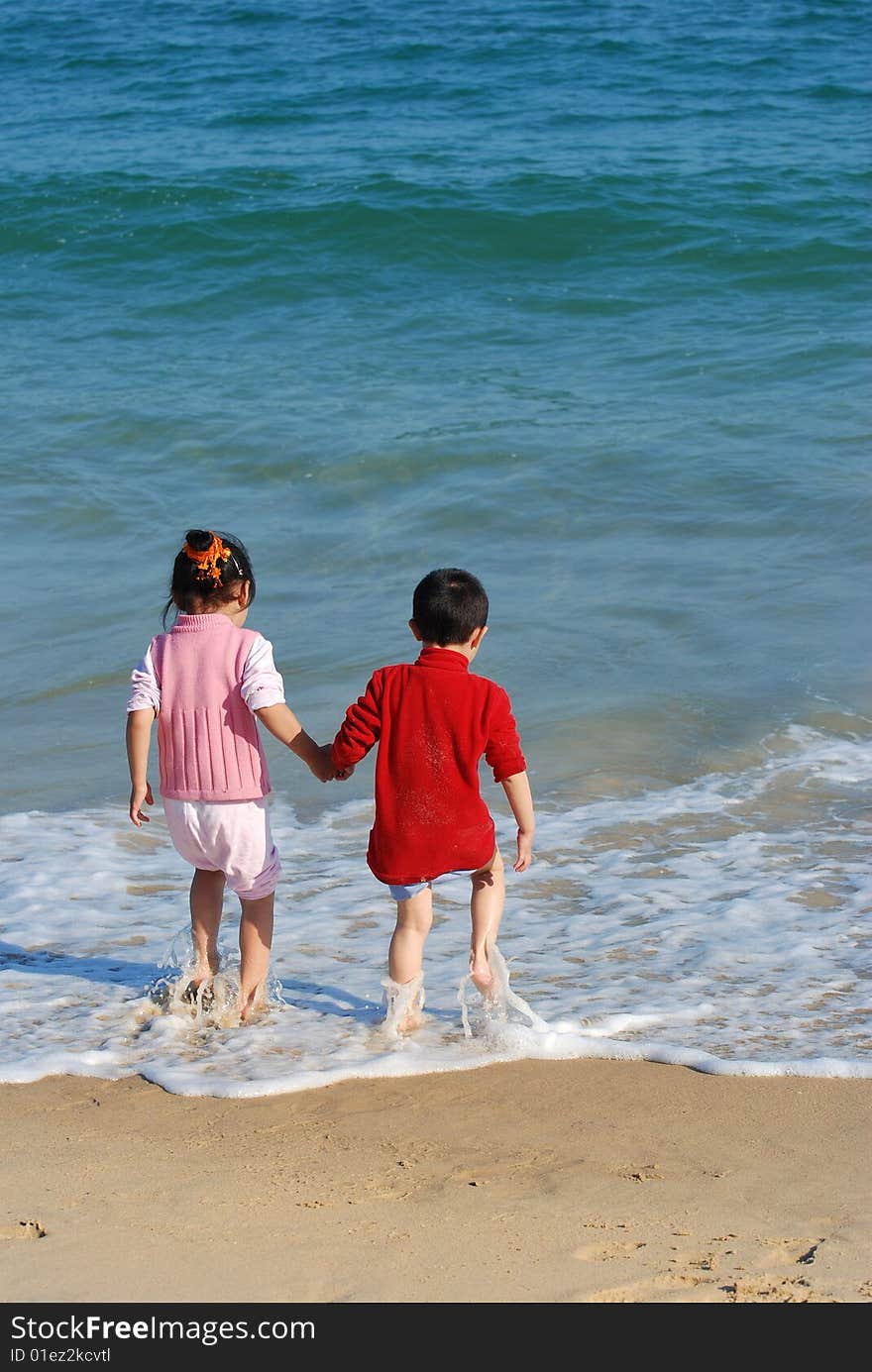 Young Kids Playing in the surfy beach