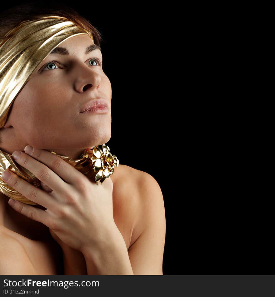 Blue-Eyed Glamour Man with Gold Bandage and Jewelry Flower. Isolated on Black Background