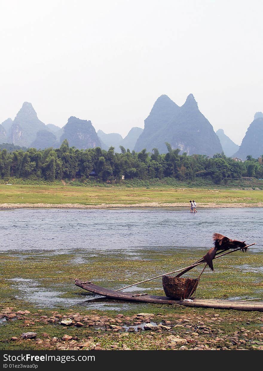 Guilin to Yangshuo cruise. fisherman's boat in the front, with lake and mountains in the background. Guilin to Yangshuo cruise. fisherman's boat in the front, with lake and mountains in the background.