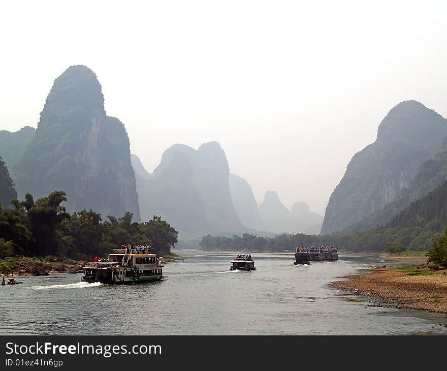 Guilin to Yangshuo cruise. convoy of tourist boats going down the river. Guilin to Yangshuo cruise. convoy of tourist boats going down the river.