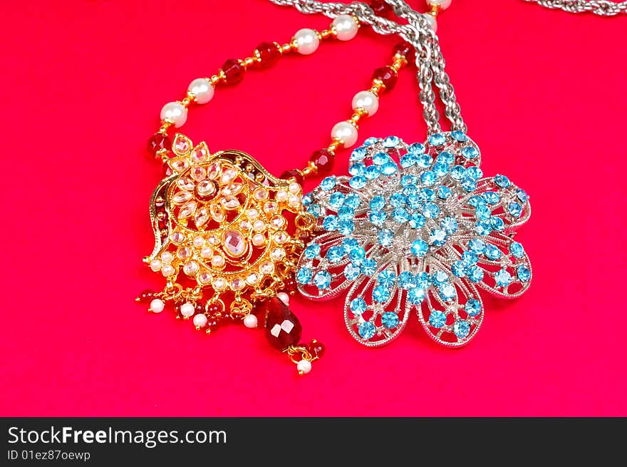 Gold and diamond pendants isolated on colored background.