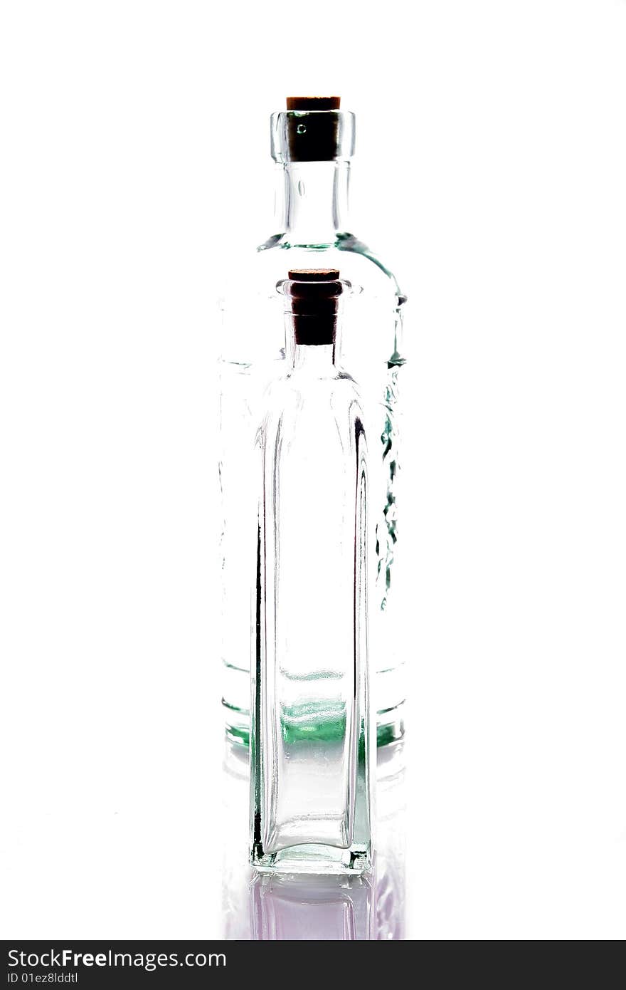 Two empty glass bottles backlit on a white background. Two empty glass bottles backlit on a white background.