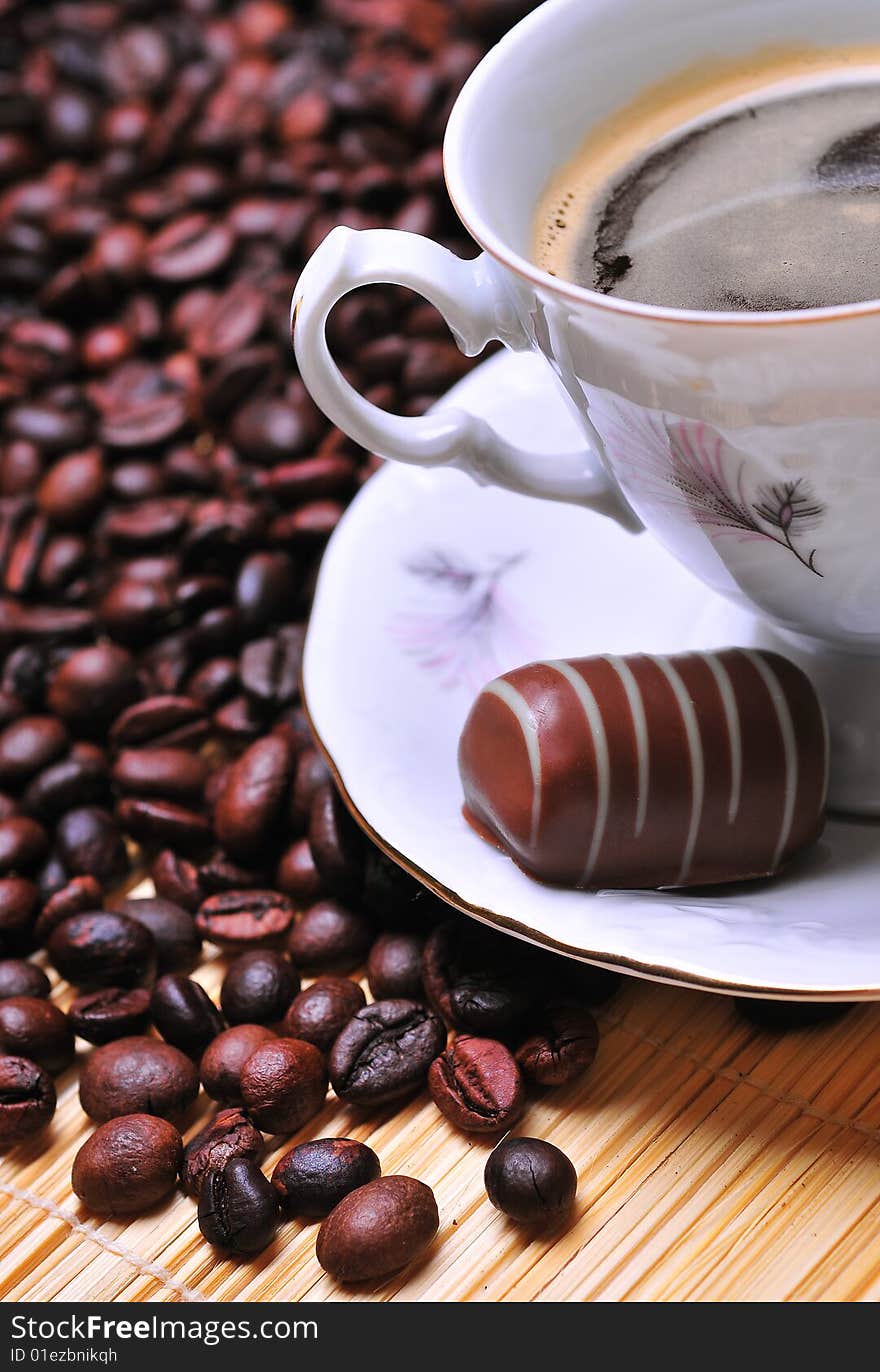 A cup of coffee with chocolate on beans. A cup of coffee with chocolate on beans