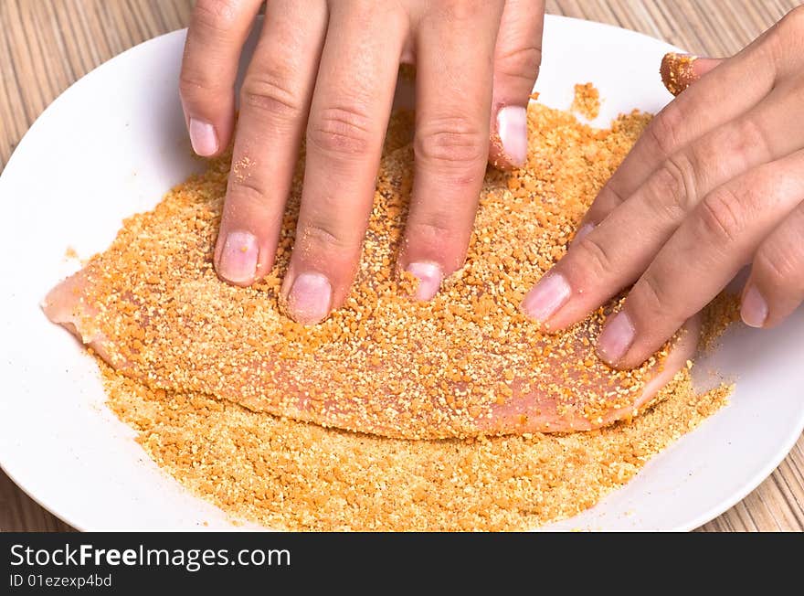 Preparing cutlets from the chicken breast. Chicken breast coated in breadcrumbs.