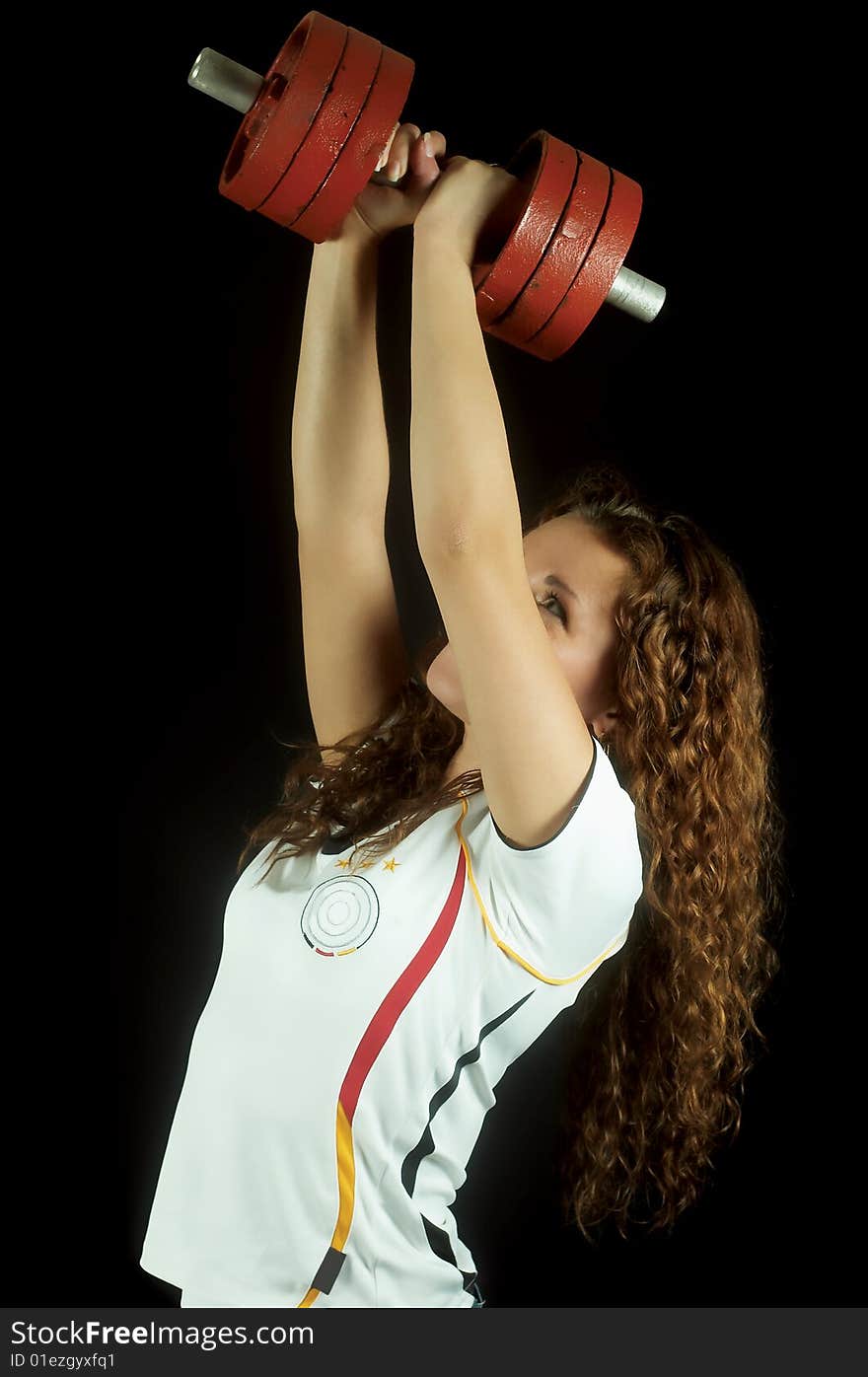 Beautiful girl raises dumbbell