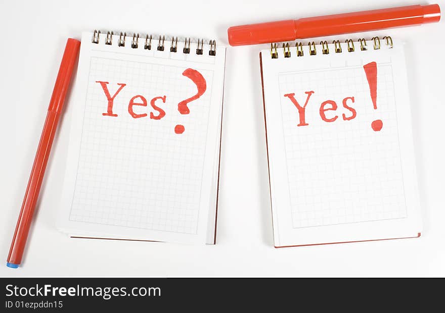 Two open notebook with inscription and red felt-tip pens