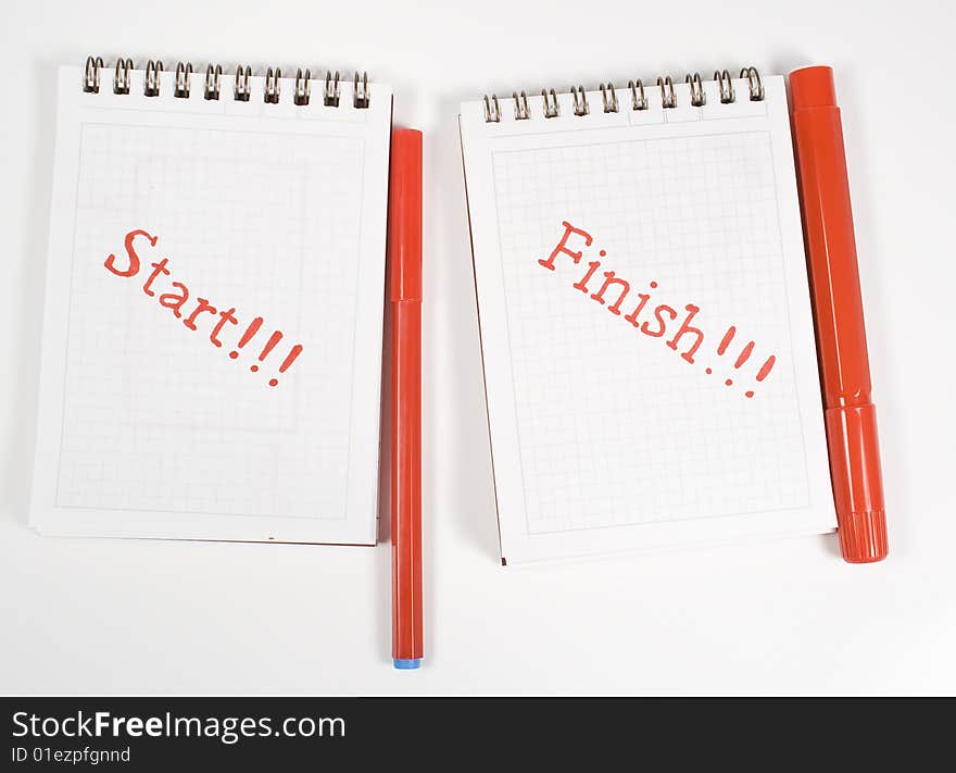 Two open notebook with inscription and red felt-tip pens