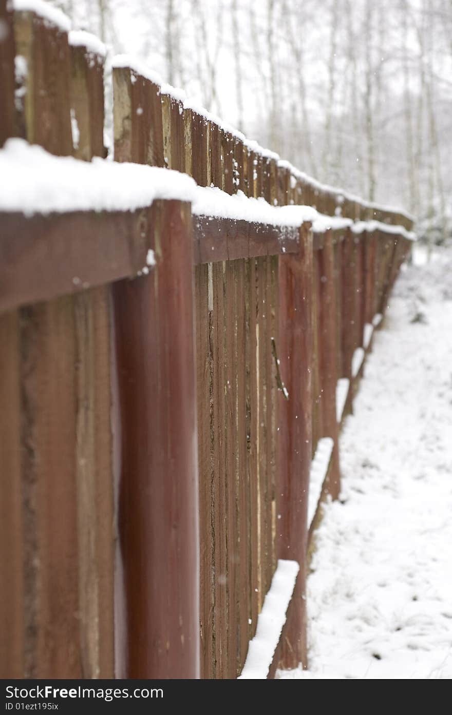 Brown fence under white snow. Brown fence under white snow