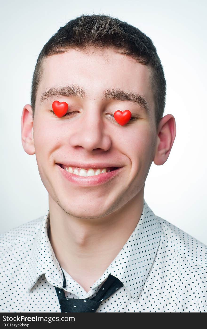 Portrait of a smiling man with heart-shaped candies over his eyes