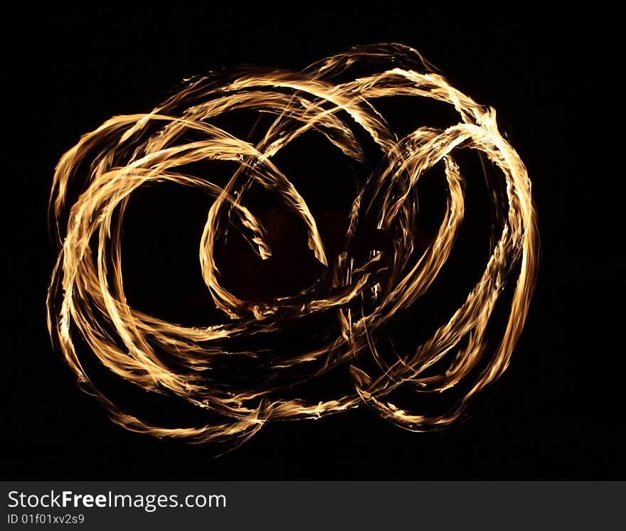 Fire dancer making circles of fire on the beach. Fire dancer making circles of fire on the beach