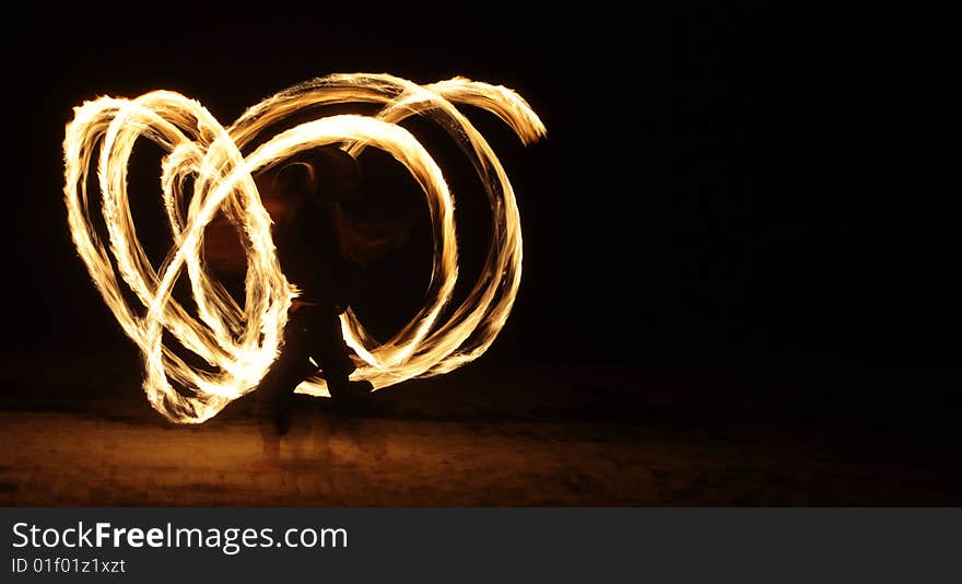 Fire dancer making circles of fire on the beach. Fire dancer making circles of fire on the beach