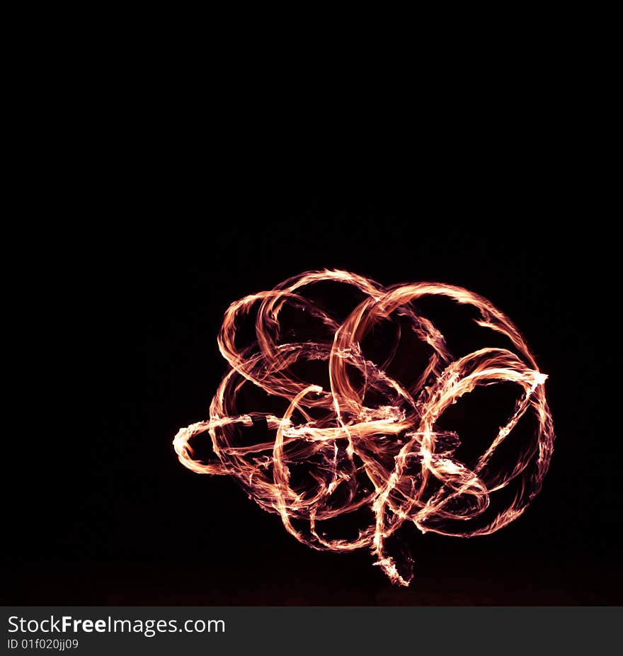 Fire dancer making circles of fire on the beach. Fire dancer making circles of fire on the beach