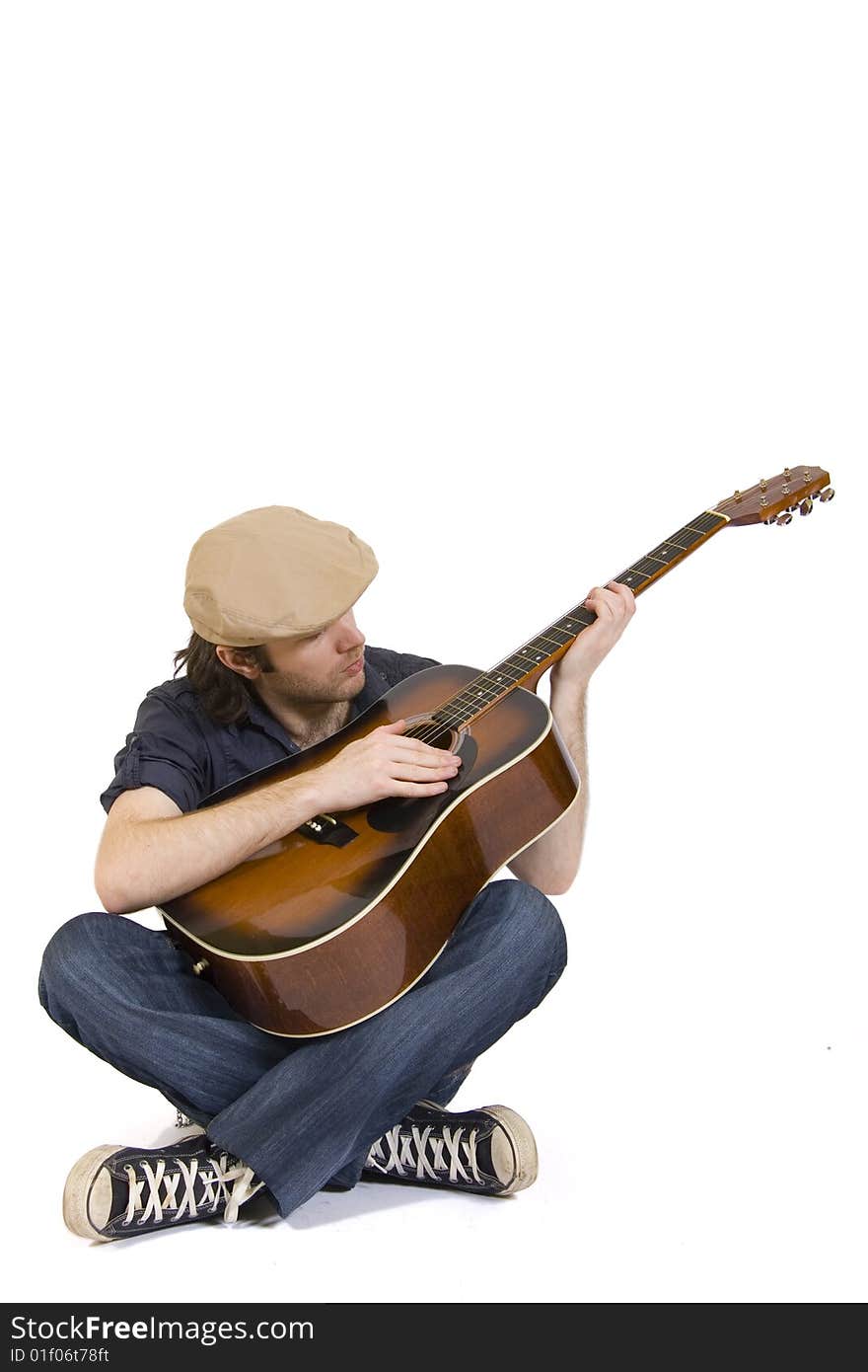 Man playing his acoustic guitar seated. Man playing his acoustic guitar seated