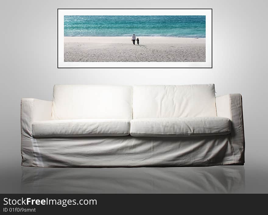 A white modern sofa with a photo of a family at the sea on the wall. A white modern sofa with a photo of a family at the sea on the wall