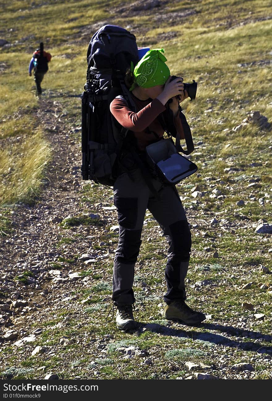 Hiker photographer in funny green bandana making a shot. Hiker photographer in funny green bandana making a shot