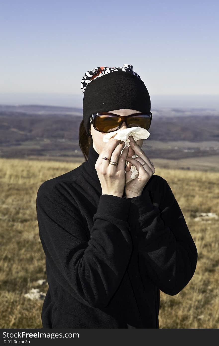 Tourist girl in sunglasses blowing her running nose. Tourist girl in sunglasses blowing her running nose