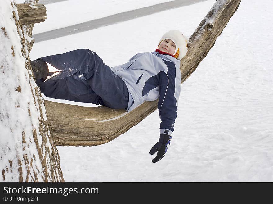 Girl on tree. Winter time, Russia. Playng child.